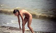 黑发裸体女孩在海滩上裸体走动