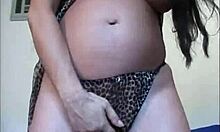 Bruneta superbă își masturbează pizda însărcinată prin chiloți